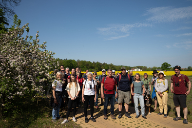 Foto: Susanne Atzenroth Gruppe von Pilgernden unter blühenden Obstbäumen auf dem neu eröffneten Mariannenweg in der Prignitz.
